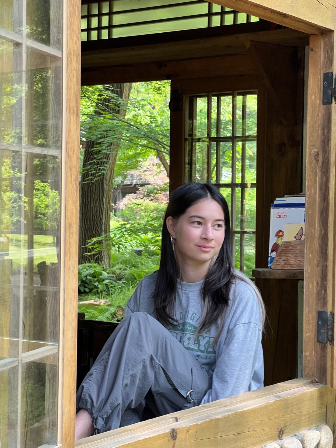 Girl sitting in windowsill looking to the right