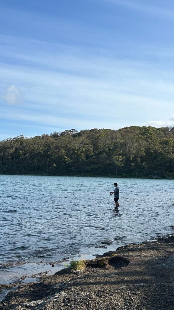 Man in the distance fishes on lake macquarie