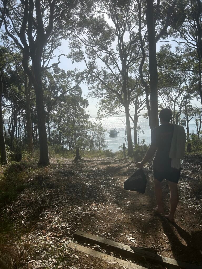 Man walks down Wangi Point circuit track towards lake macquarie